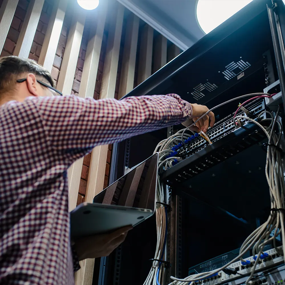 Technician working on a network server rack